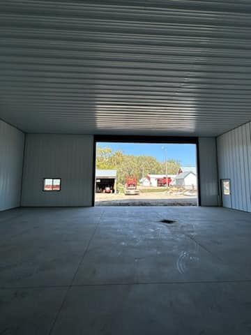 A large empty garage with a large garage door open.