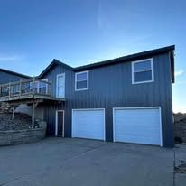 A large house with two garage doors and a deck.