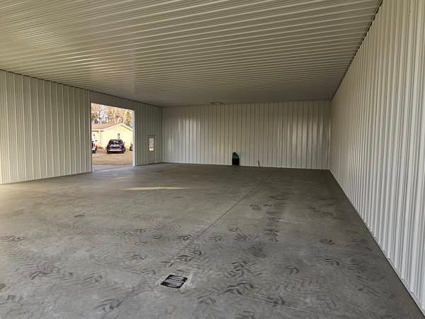 A large empty garage with a concrete floor and white walls.