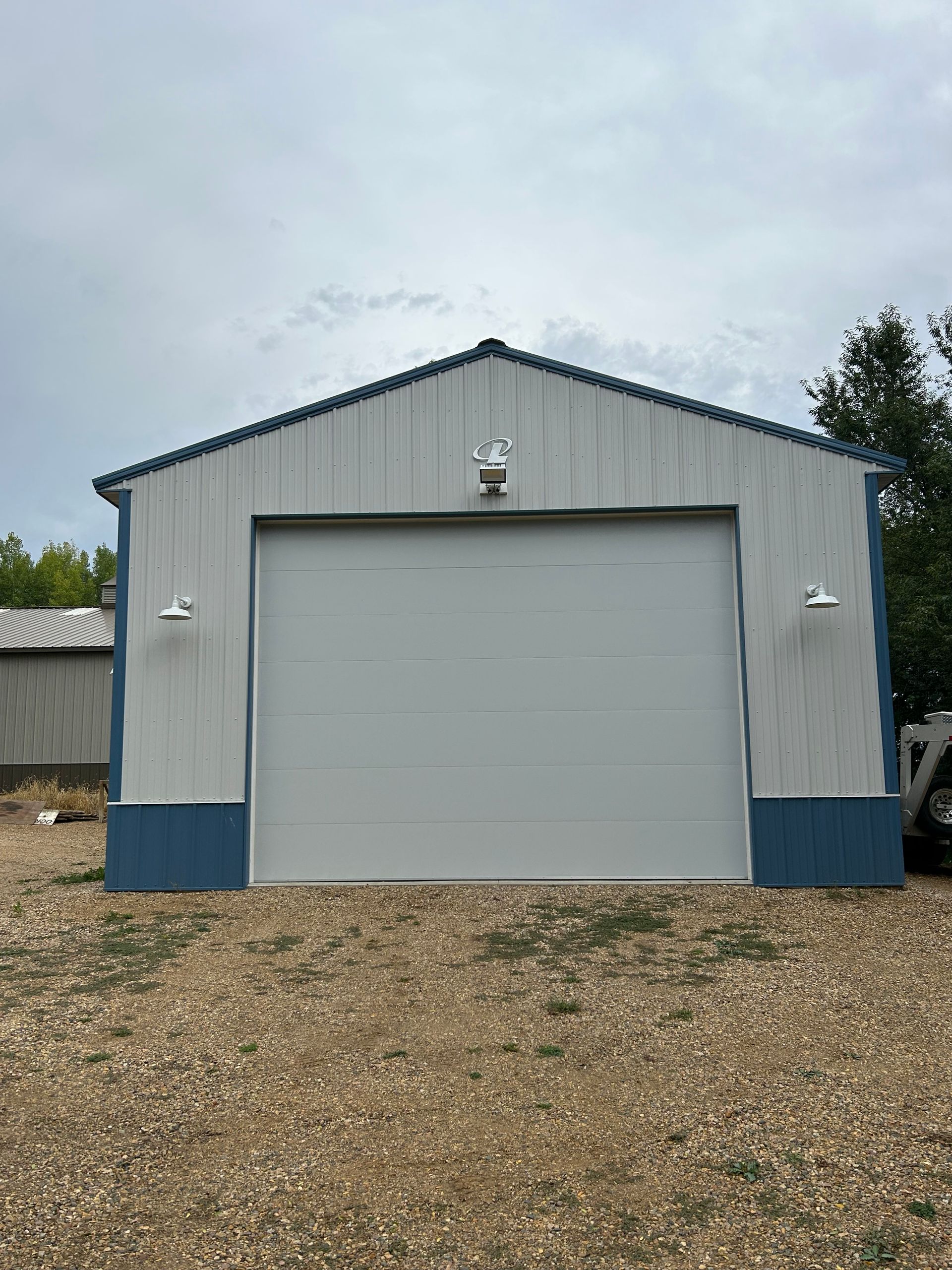 A white and blue garage with a large garage door.