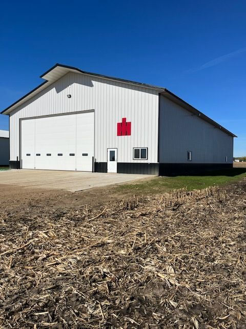 A large white barn with a red cross on the side
