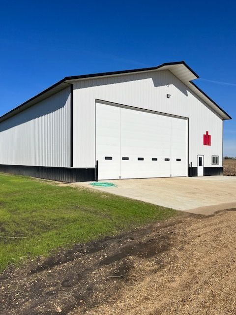 A large white barn with a large garage door
