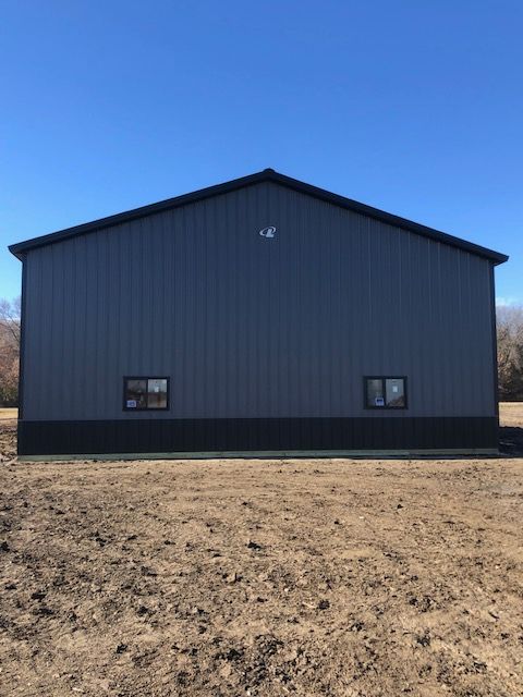 A large building is sitting in the middle of a field.