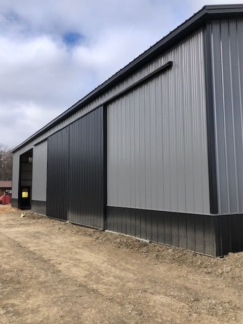 A large gray and black building with a sliding door.
