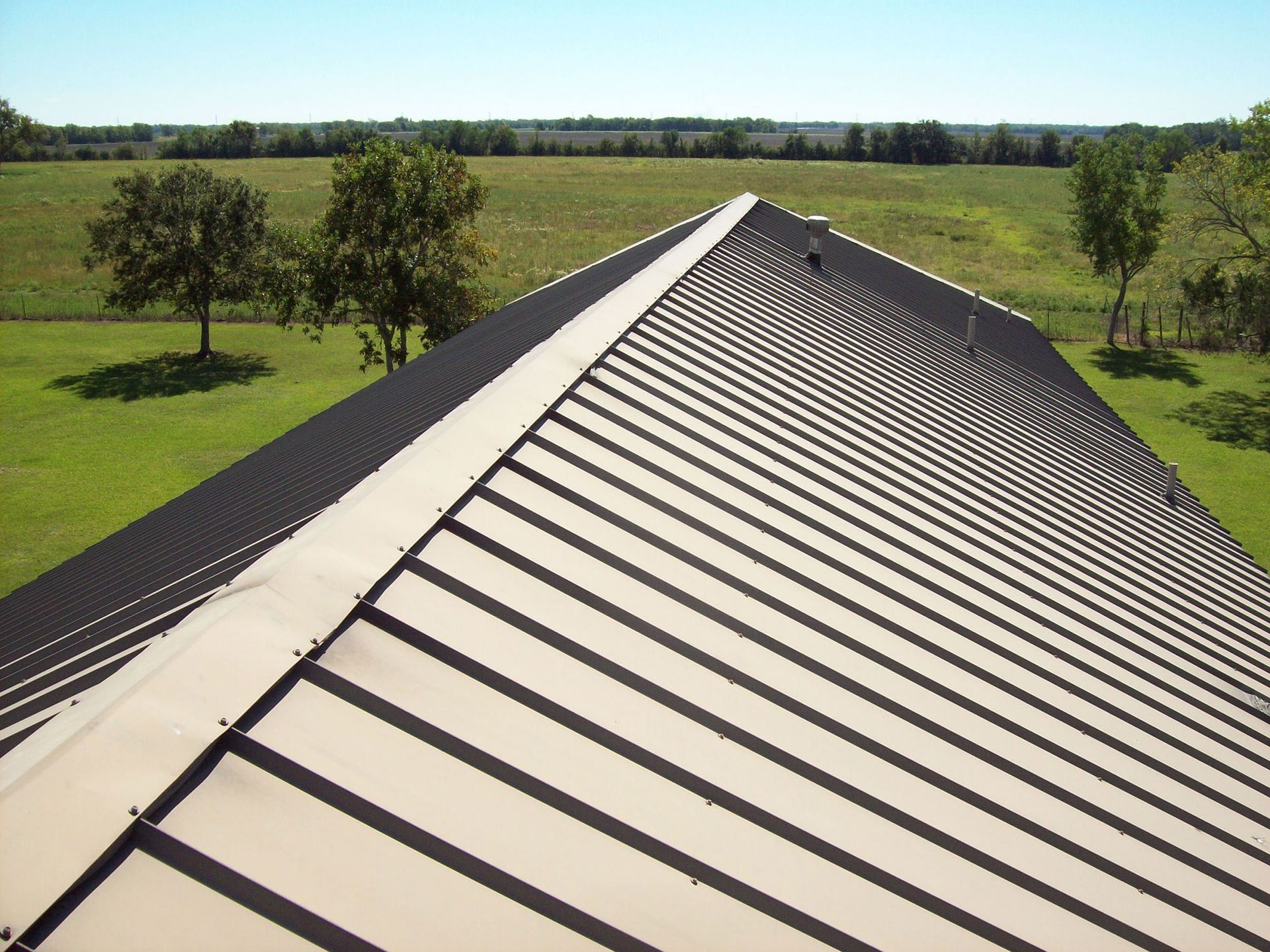 The roof of a building with a field in the background
