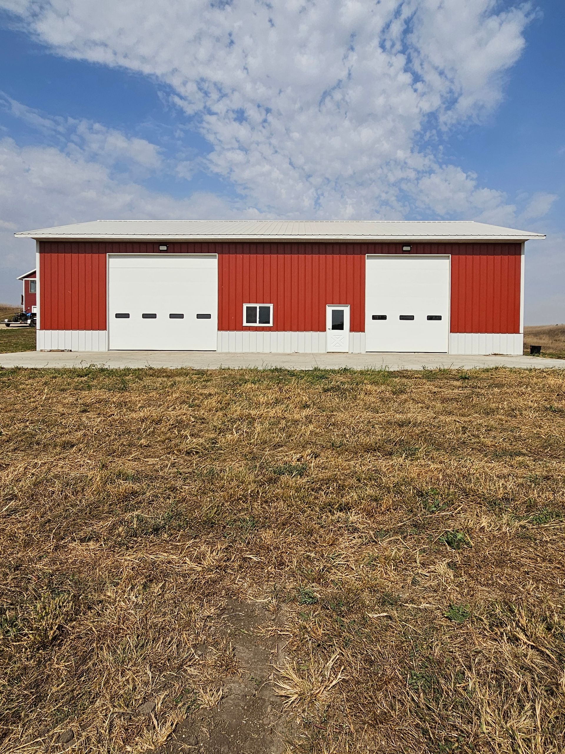 A red and white barn is in the middle of a field