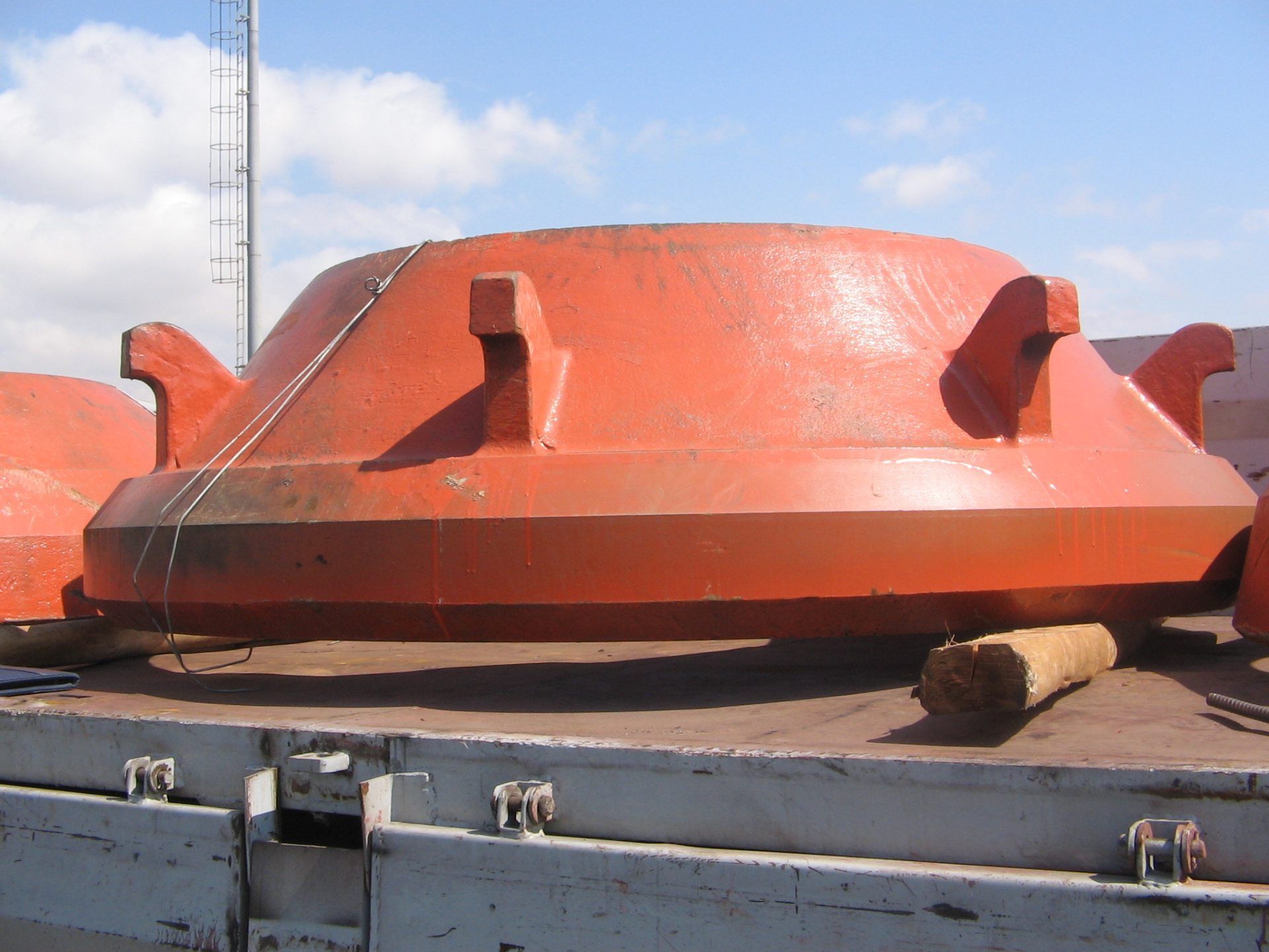 A large orange object is sitting on the back of a truck