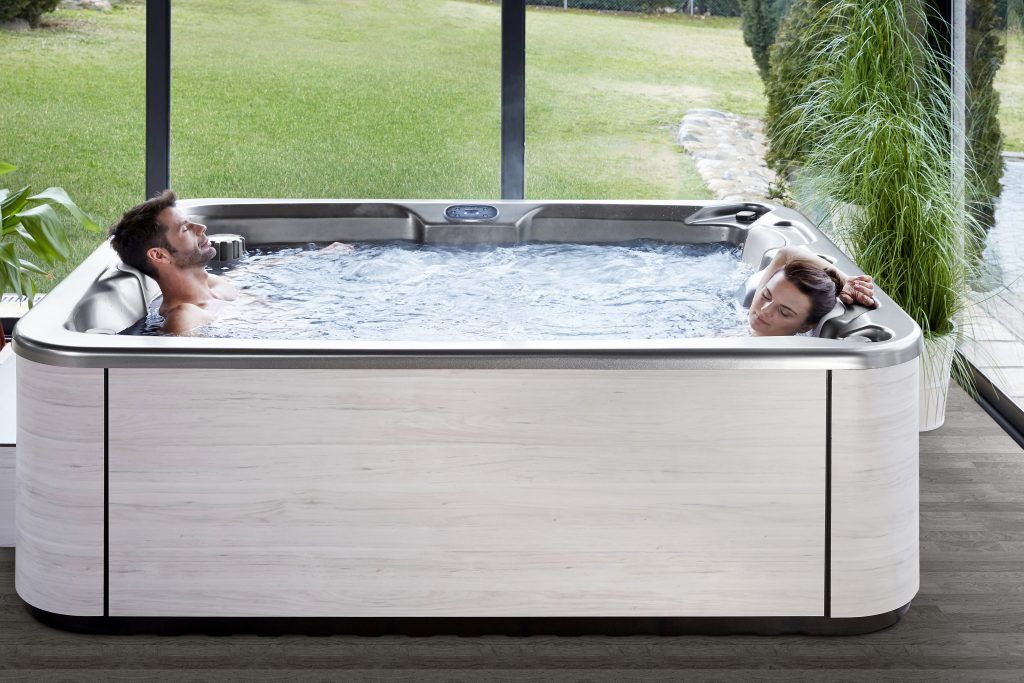 a couple enjoying a 3 person hot tub by hypa spa