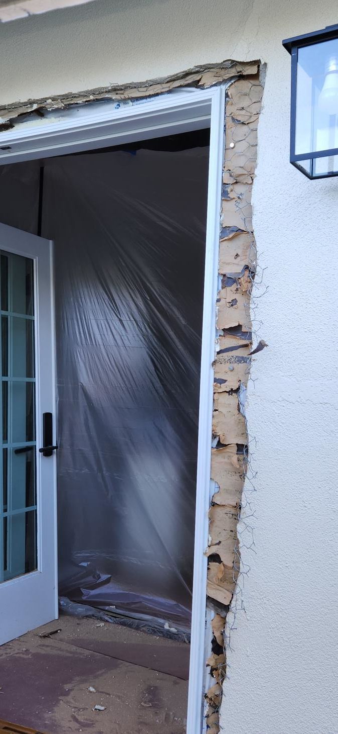 A handyman is installing a wood door and is seen in the process of tightening the lock.