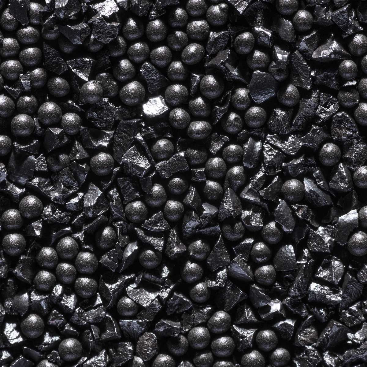 Palline sferiche grigio scuro e pezzi irregolari e spigolosi.