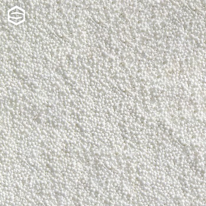 Vista ravvicinata di una superficie ricoperta da numerose piccole particelle sferiche bianche.