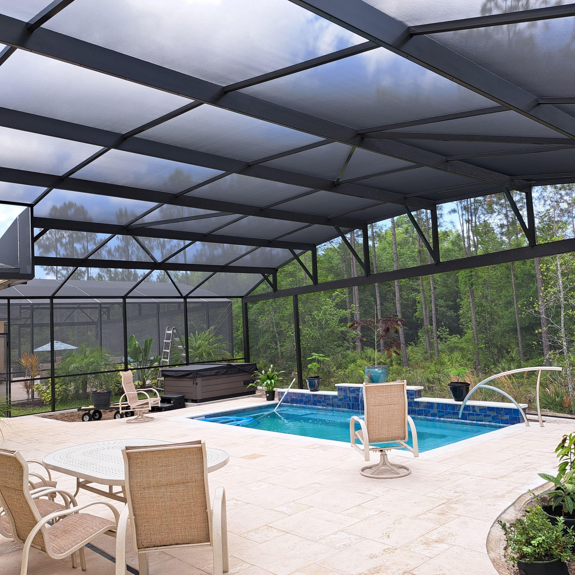 A screened in area with a swimming pool and chairs