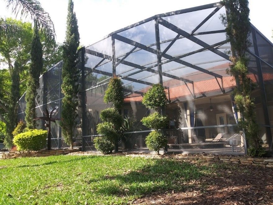 A house with a screened in porch and trees