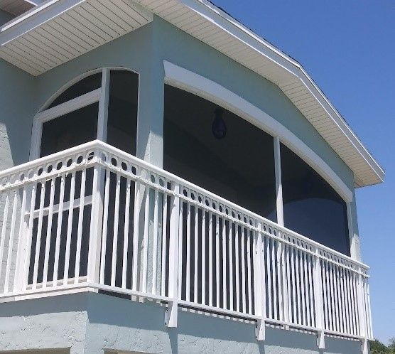 A Balcony With a White Railing on the Side of a House