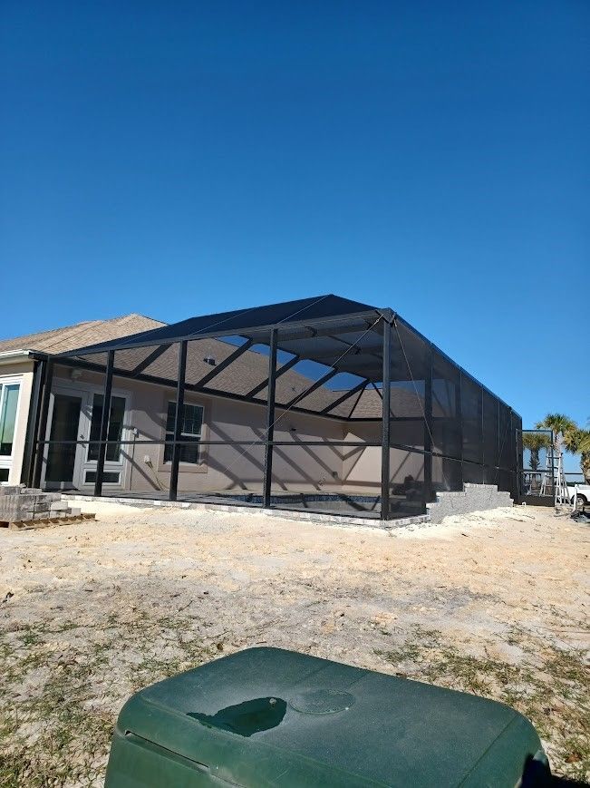 A screened in porch is being built in front of a house.
