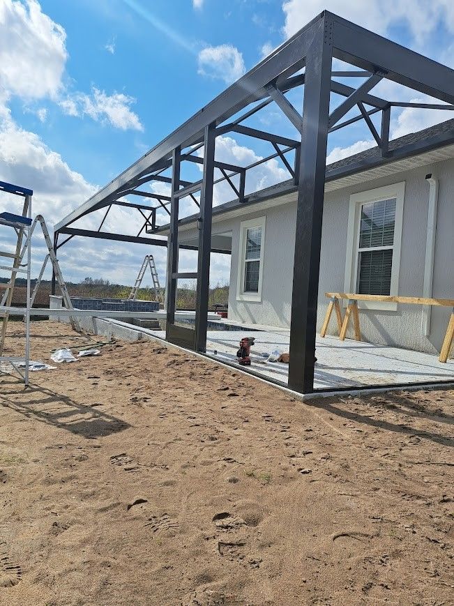 A house is being built in the dirt with a metal structure.
