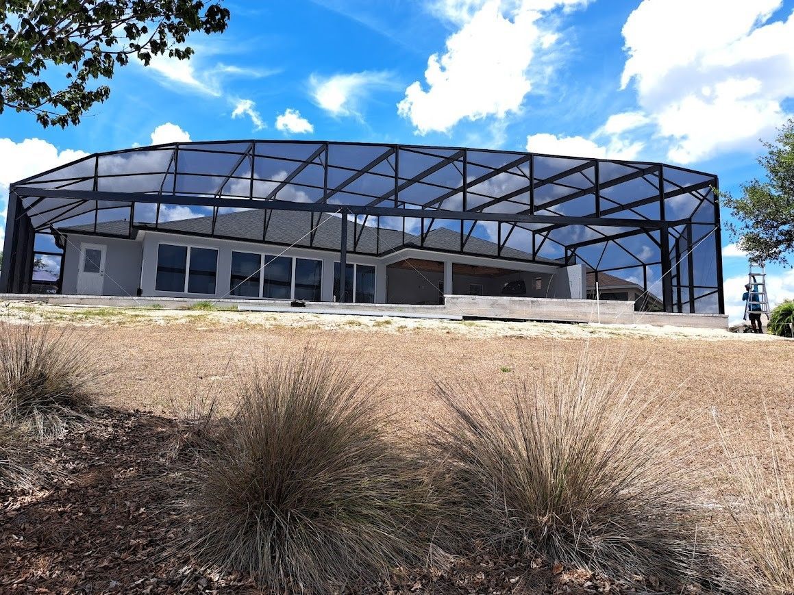 A large building is sitting on top of a dry grass field.