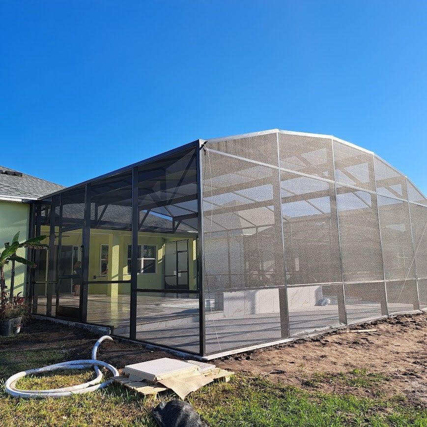 A screened in porch is being built in the backyard of a house.