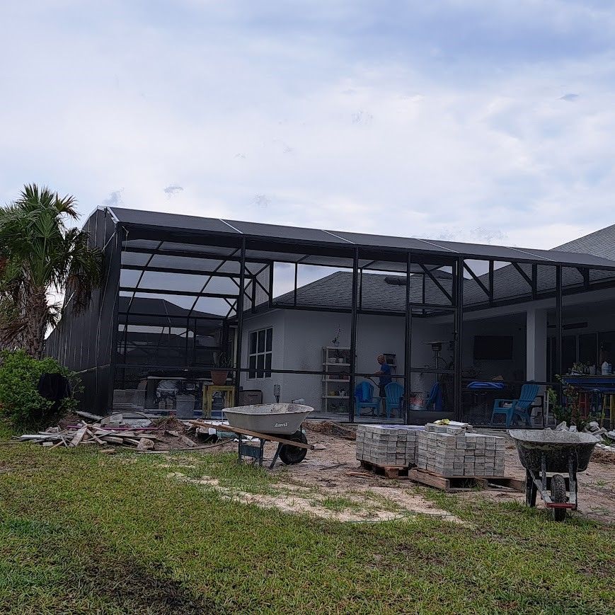 A large building is being built in the backyard of a house.