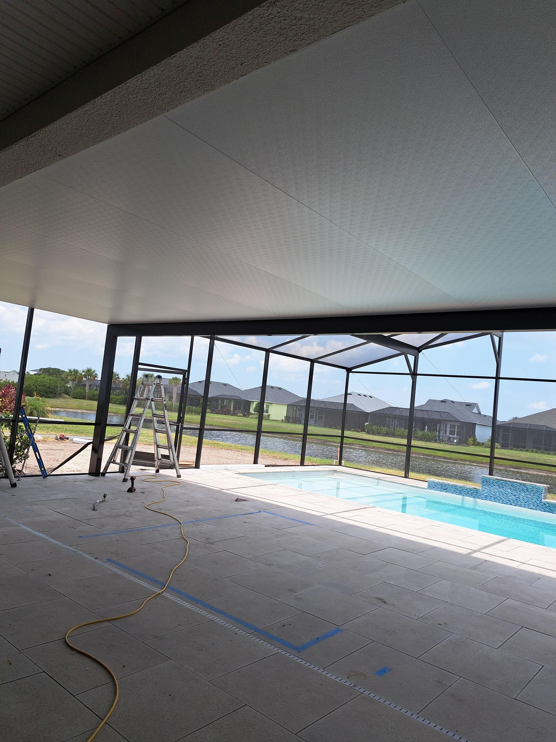 A screened in area with a swimming pool in the background