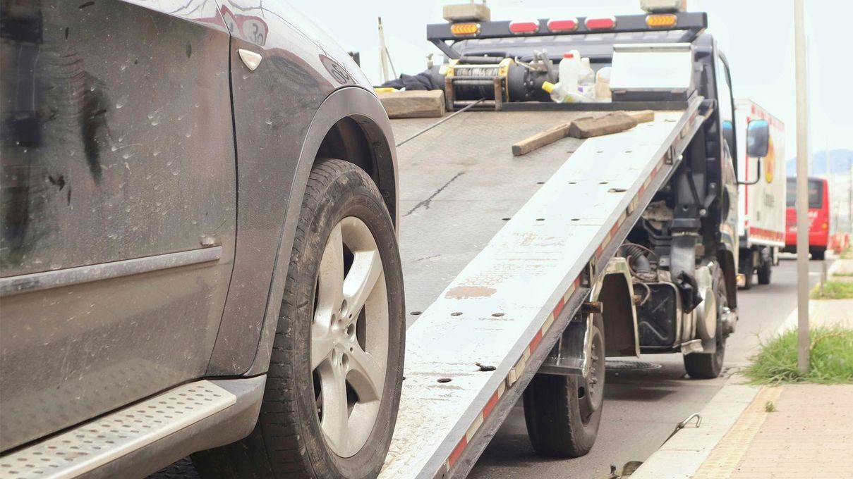 A car is being towed by a tow truck.