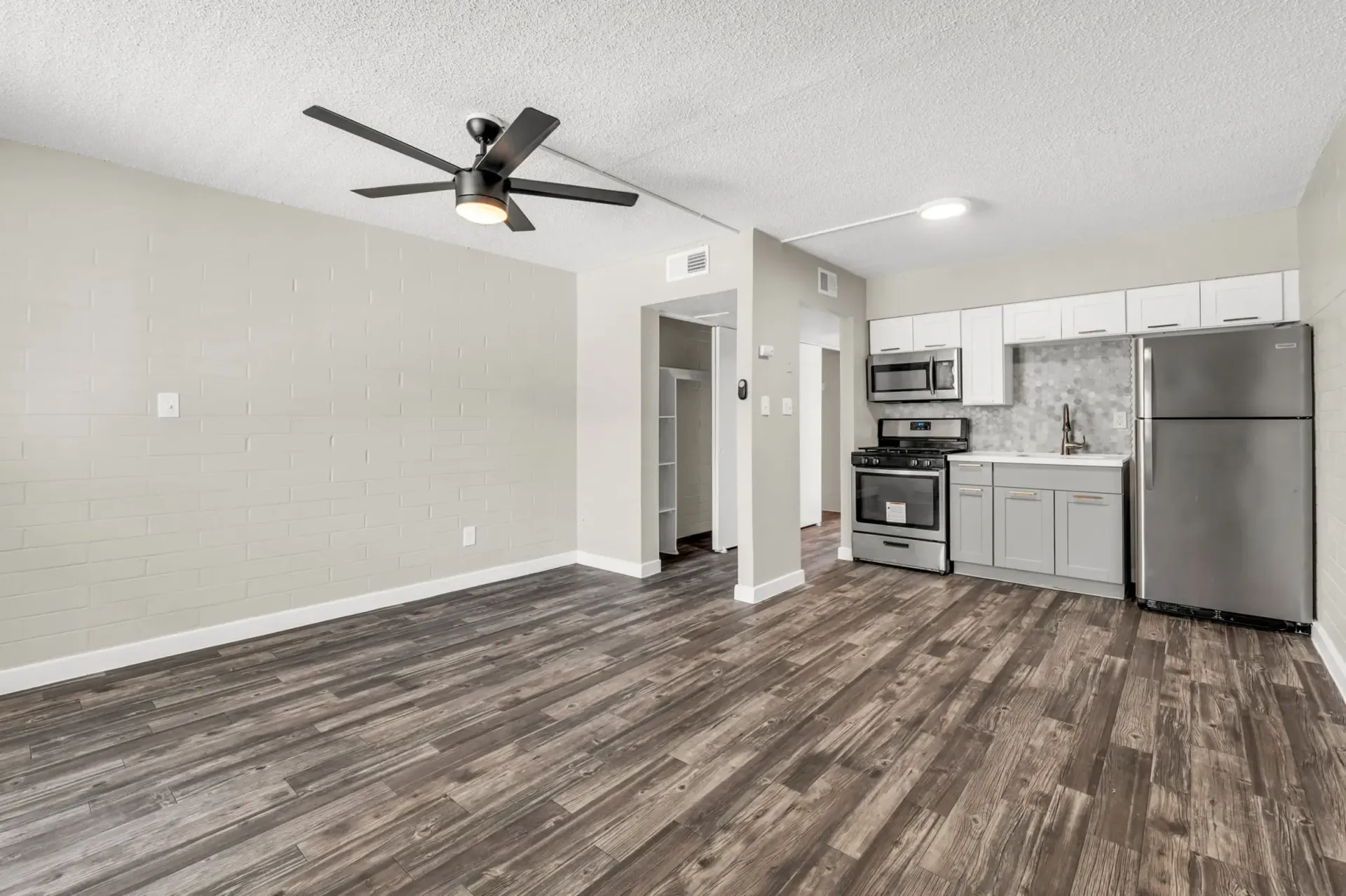 a kitchen with stainless steel appliances and a ceiling fan