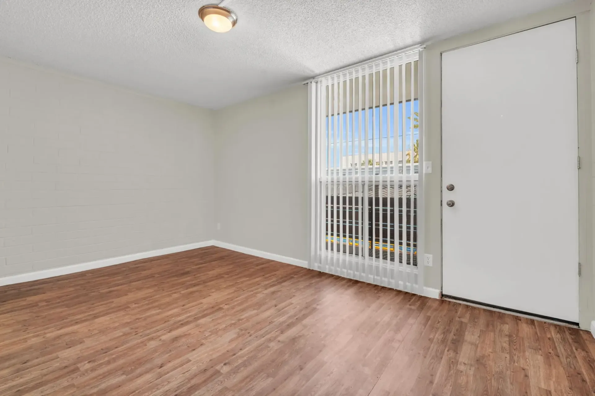 an empty room with hardwood floors and a white door