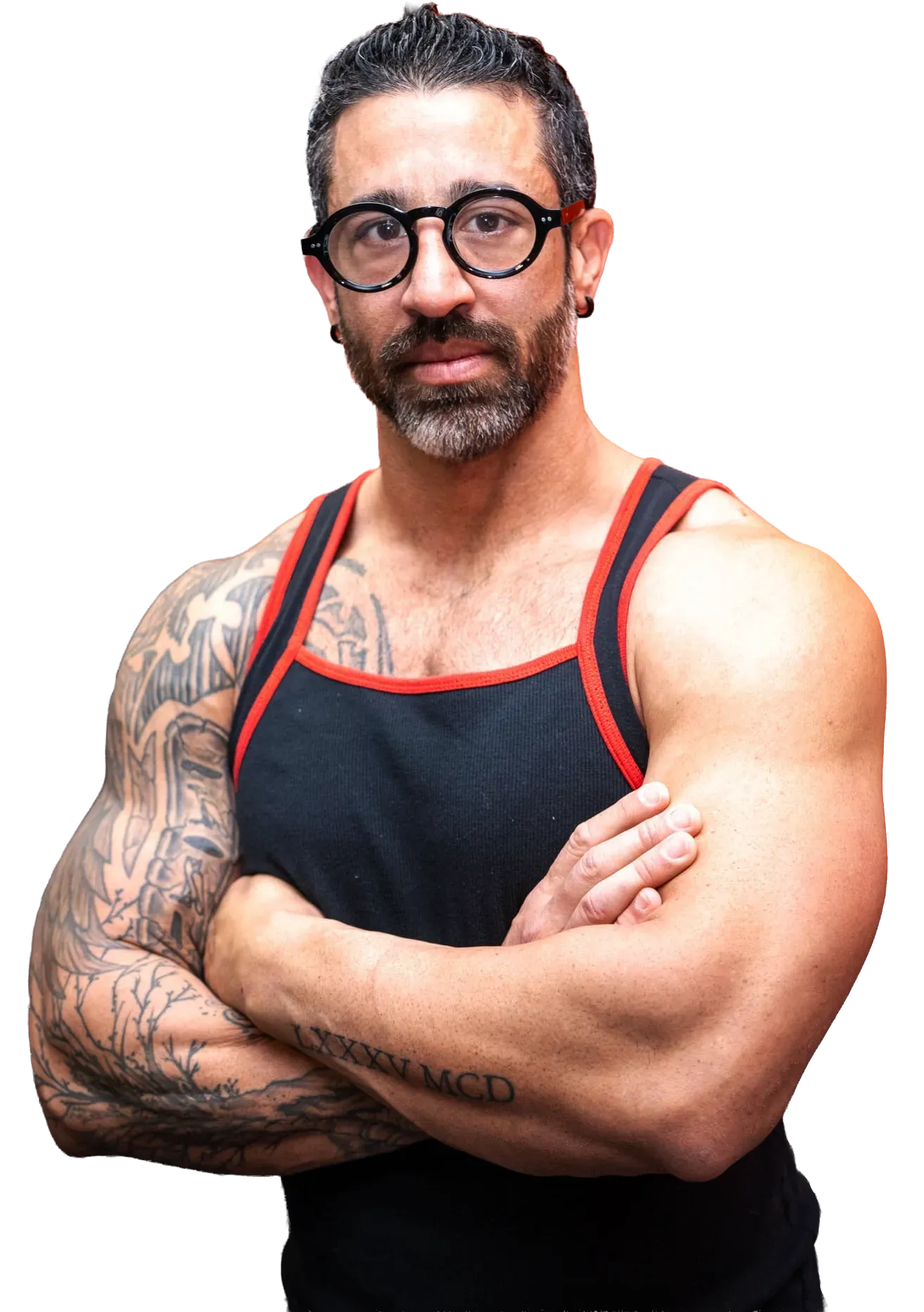 Man with glasses, arms crossed, muscular build, tattoos, wearing a black tank top with orange trim. LD FITNESS