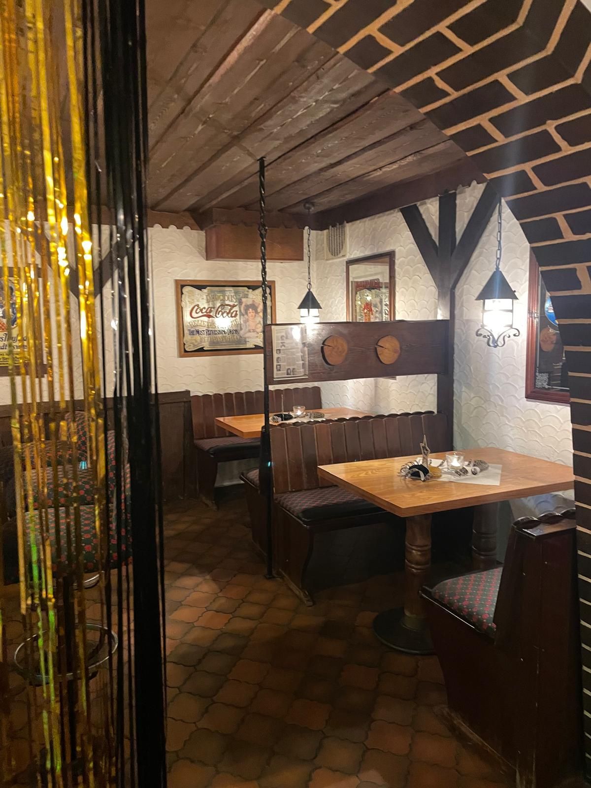 Ein Restaurant mit Tischen und Bänken und einer Backsteinmauer.