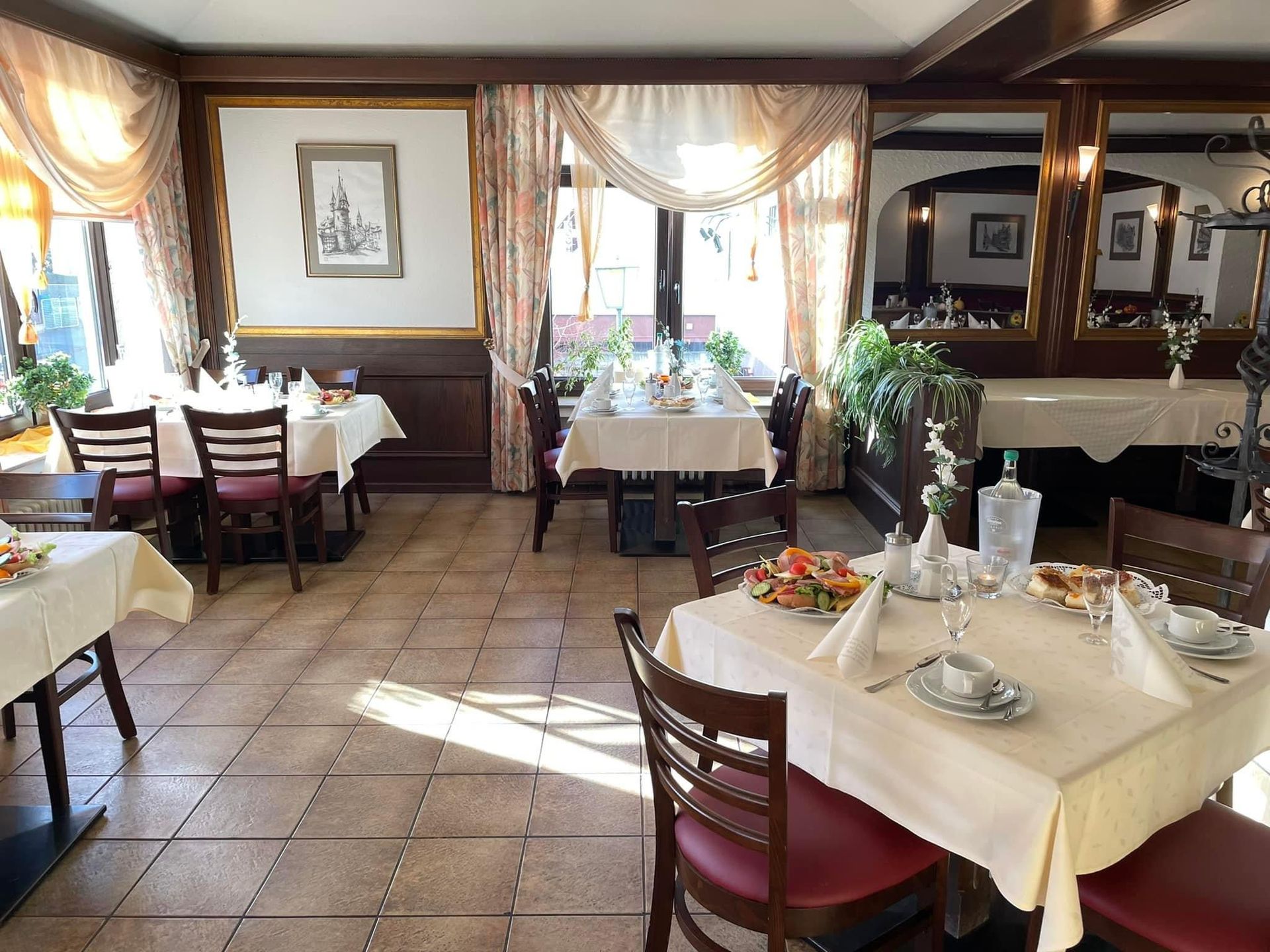 Ein Restaurant mit Tischen und Stühlen mit weißen Tischdecken