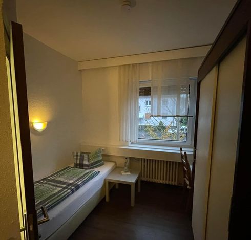 Ein Schlafzimmer mit einem Einzelbett und einem Fenster