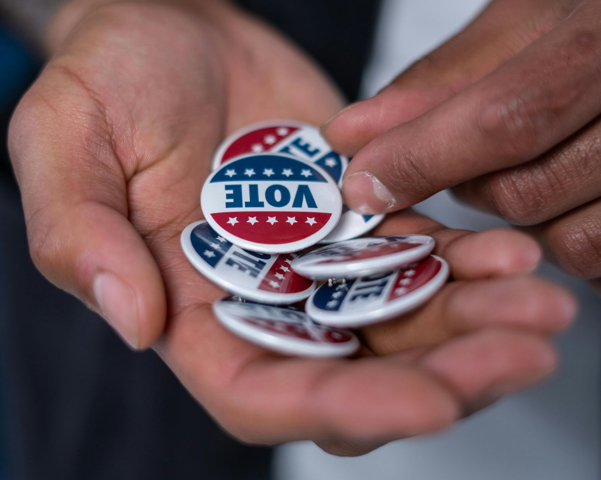 Voter pins in the hand of a poll worker