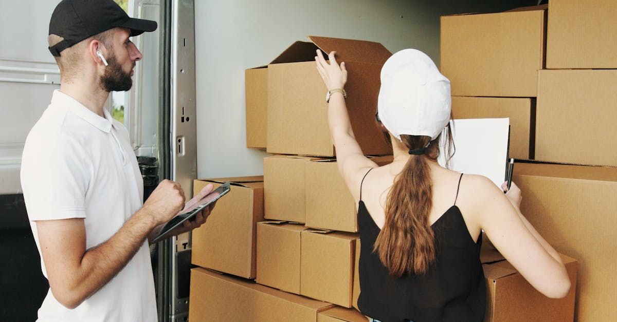 A man and a woman are standing in front of a stack of cardboard boxes.