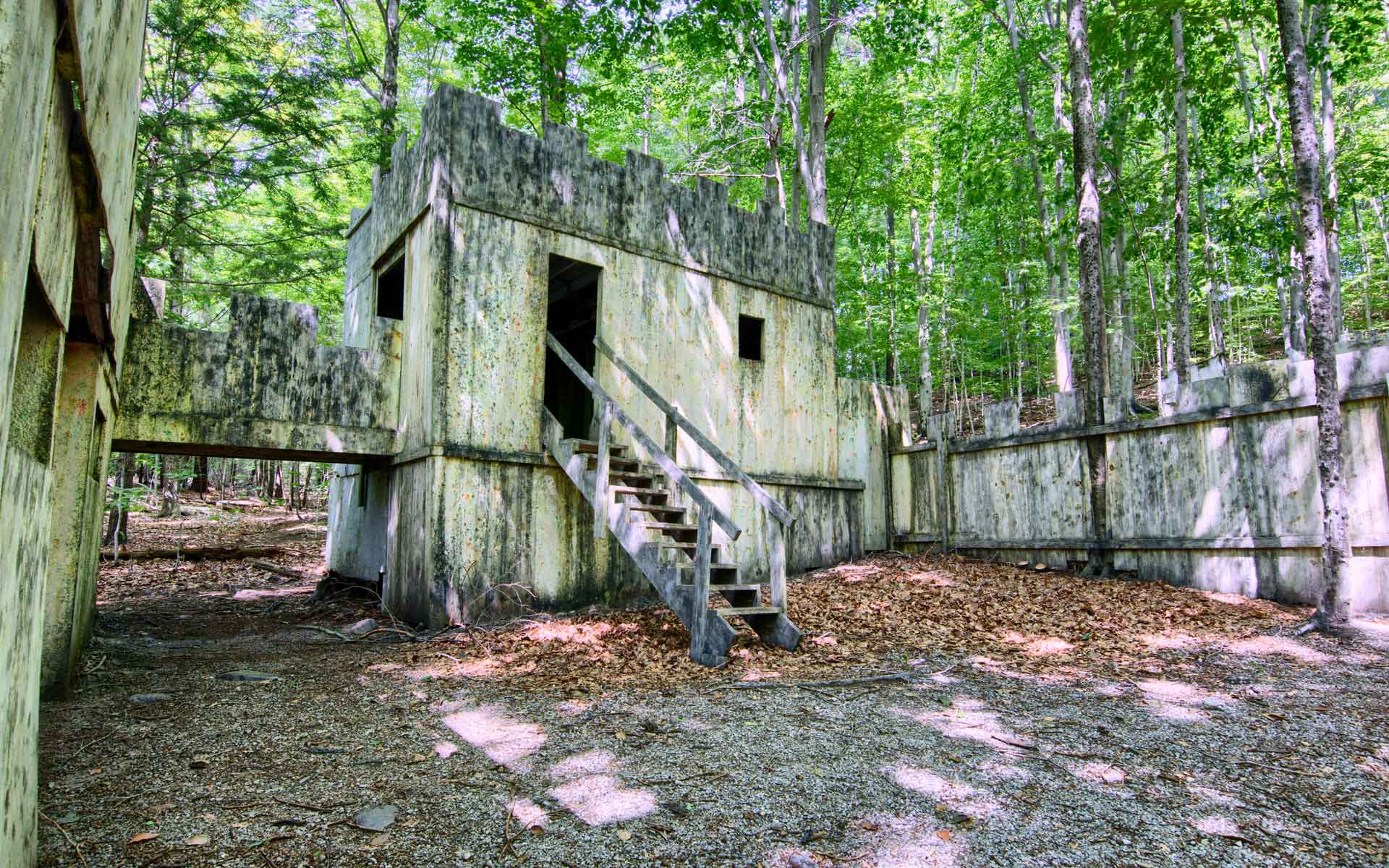 A paintball course with wooden structures in a forest setting.