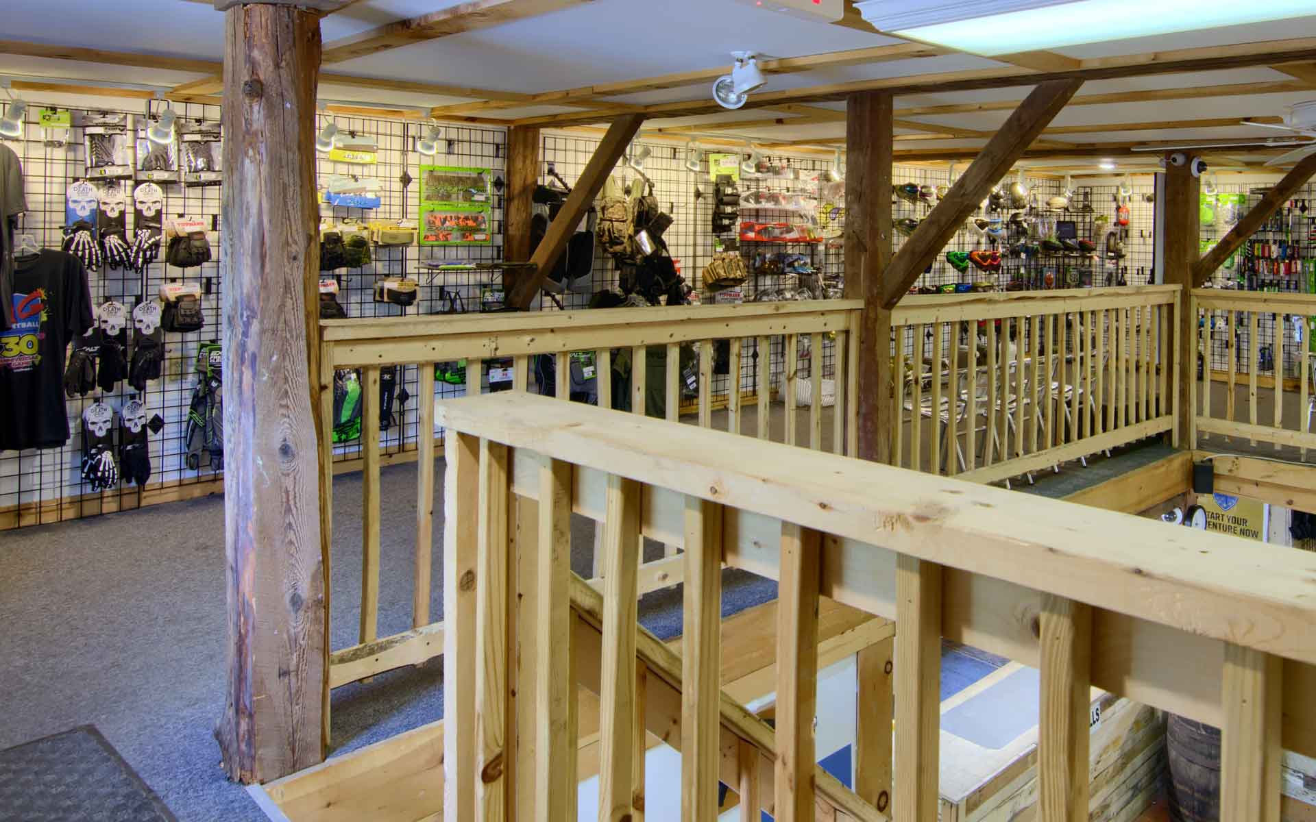 Interior of a store with a wooden second level and various products on display.