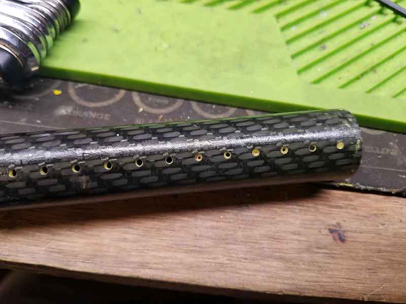 Carbon fiber tube with evenly spaced holes, possibly for a project.