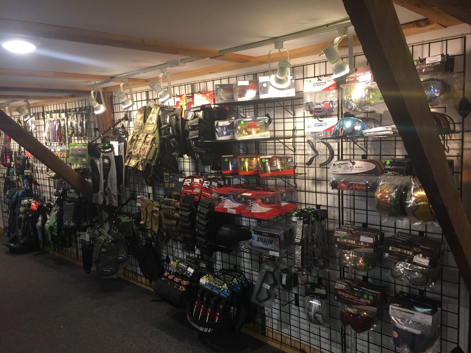 Inside a store with shelves displaying various sports equipment, possibly paintball or airsoft gear.