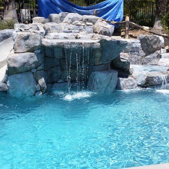 Waterfall cascading into a turquoise pool surrounded by rock formations.