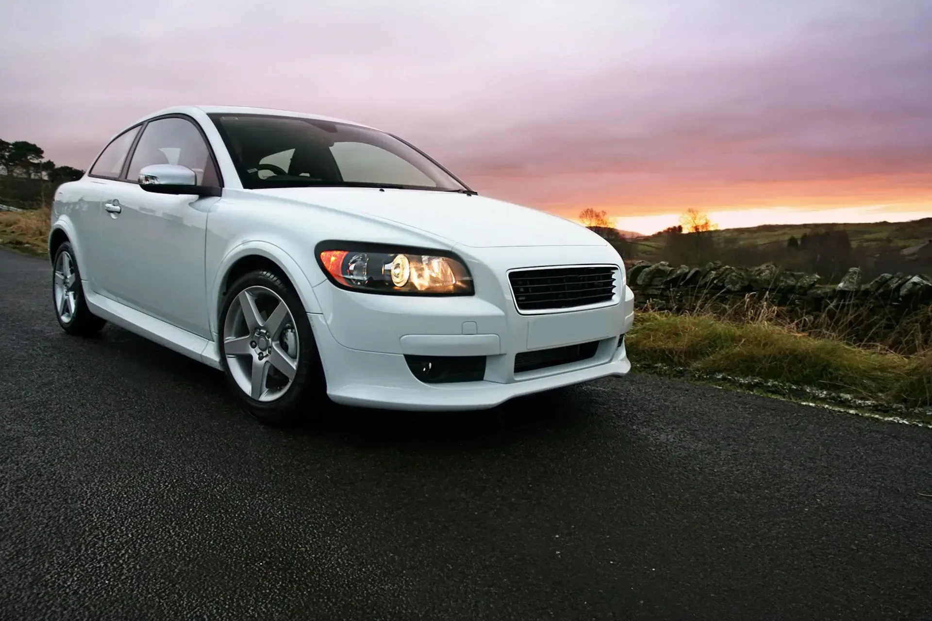 A white car is parked on the side of a road at sunset | Gary Jackson Motors