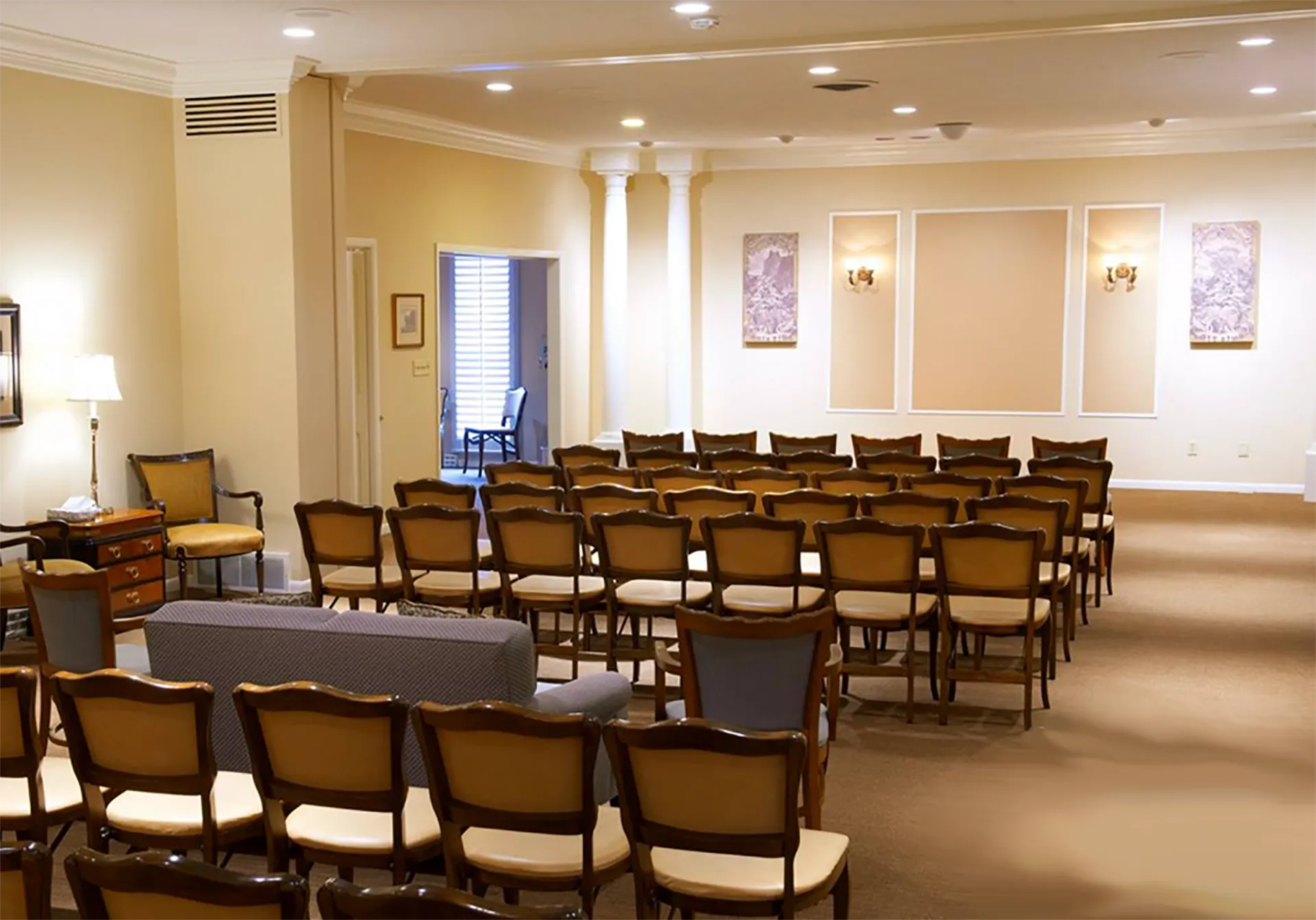 The front door of a house with a porch and plants in front of it.
