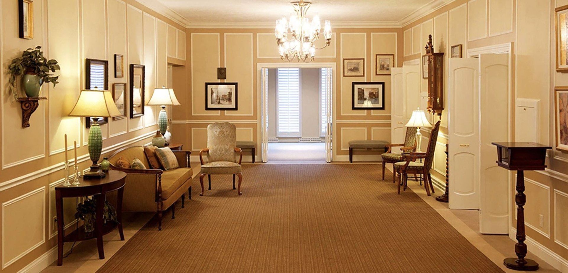 An artist 's impression of a hotel lobby with a couch , chairs , and plants.