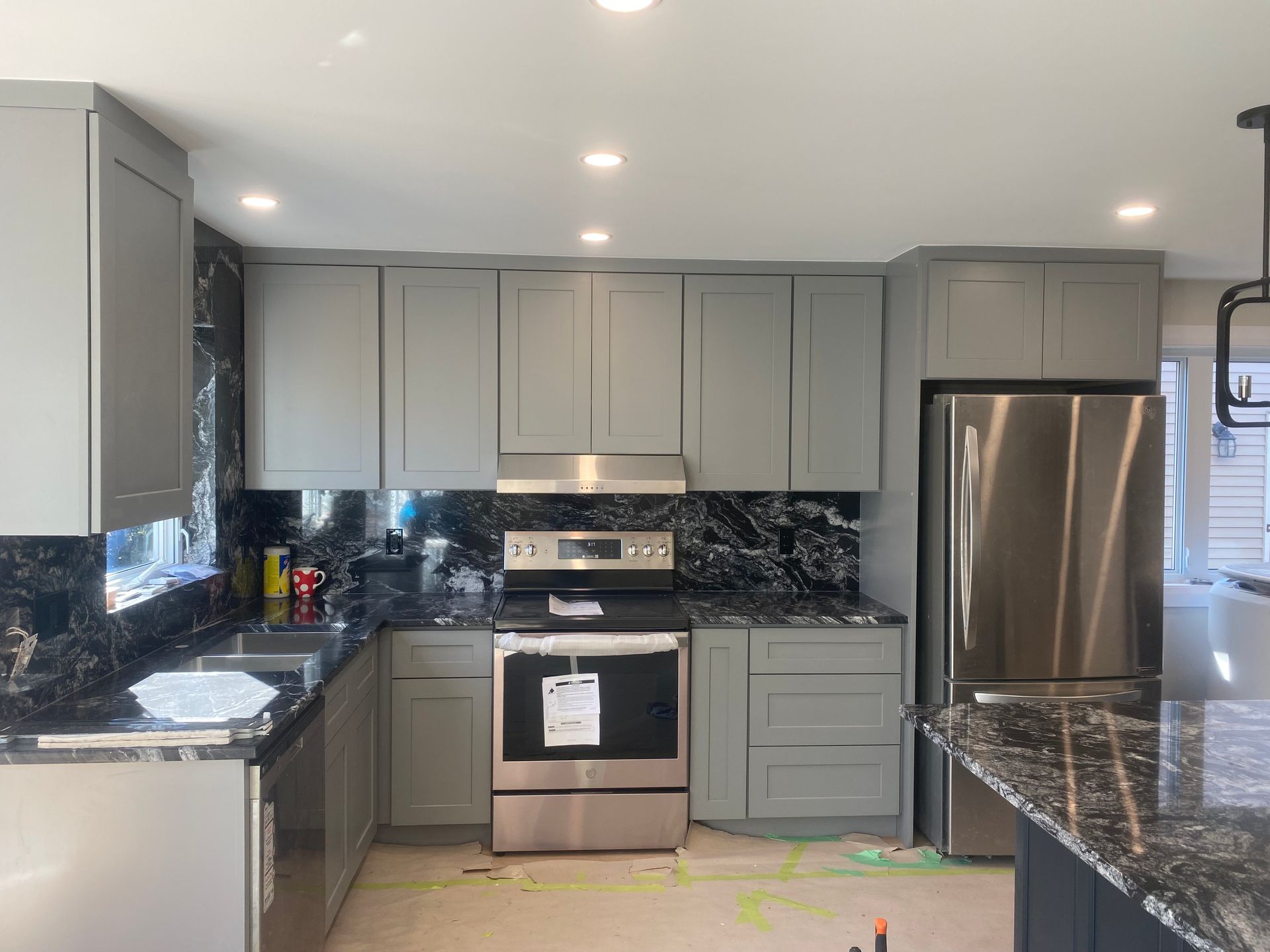 Gray kitchen with black granite countertops and stainless steel appliances.