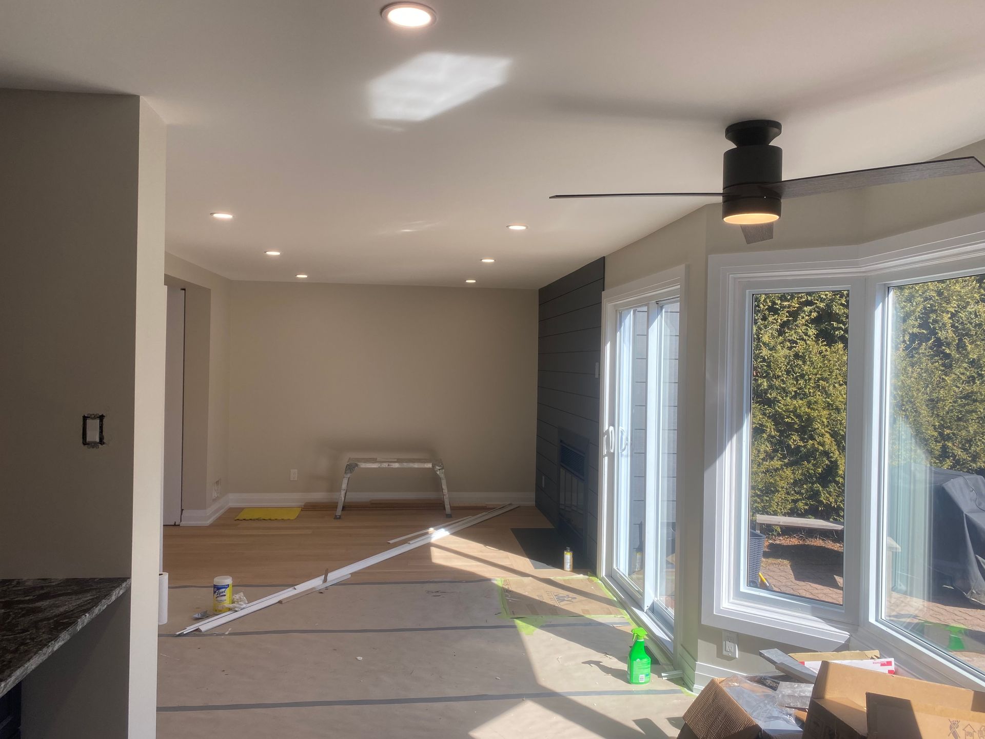 Interior room under construction with new windows and recessed lighting.
