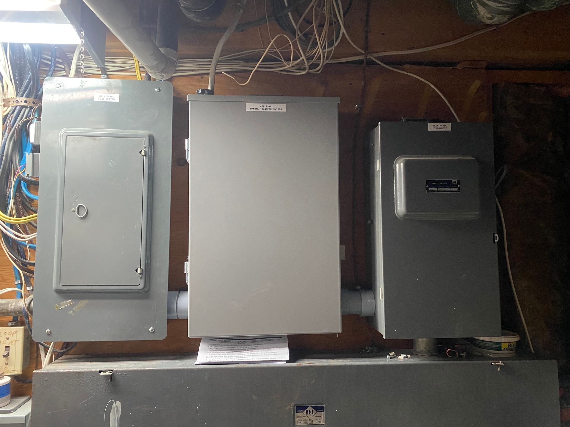 Three gray electrical panels mounted on a wall.