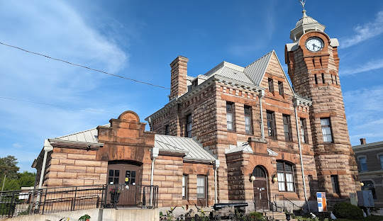Brick building with clock tower under a blue sky.