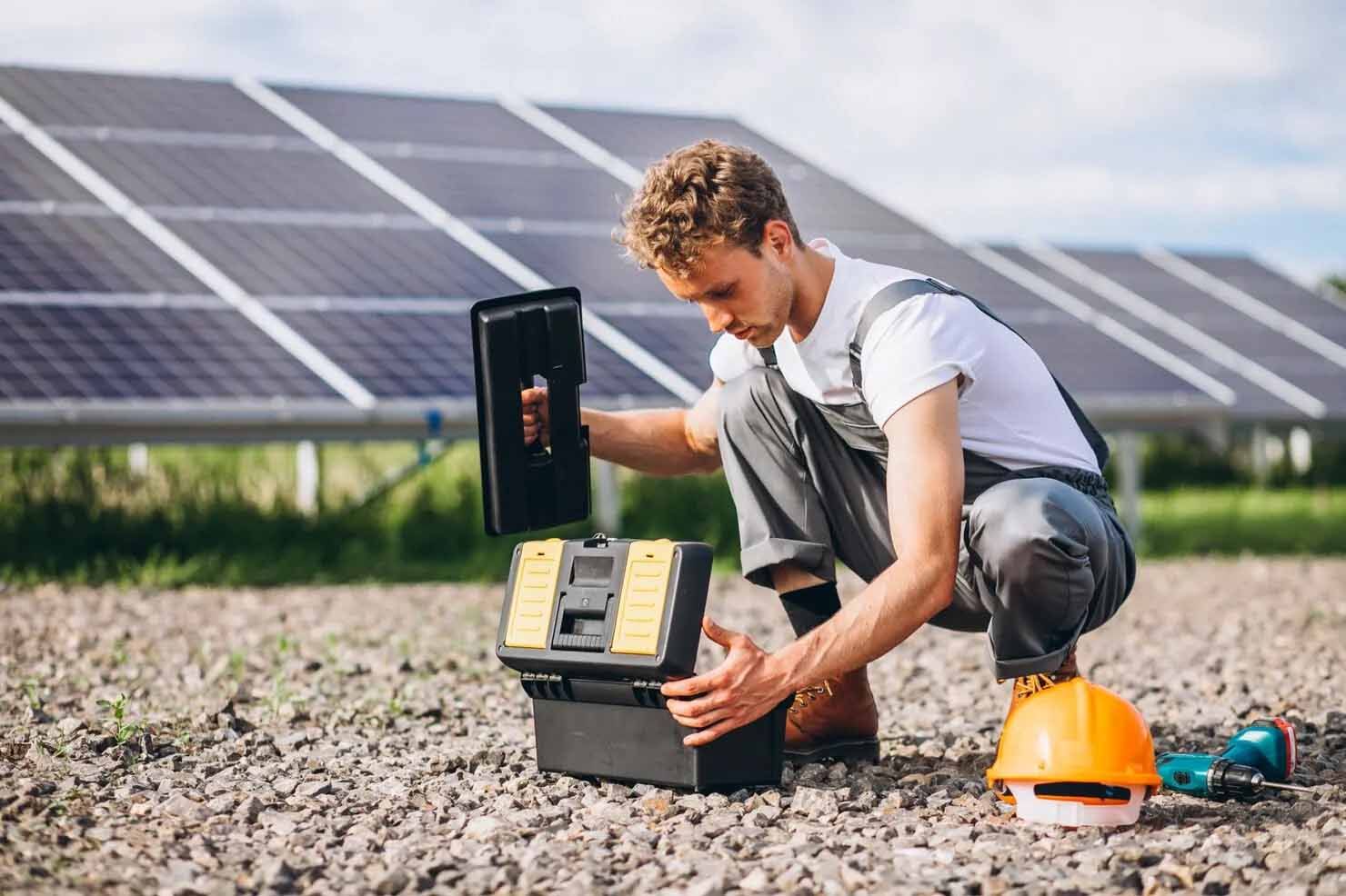 Technician opening a toolbox in front of solar panels.