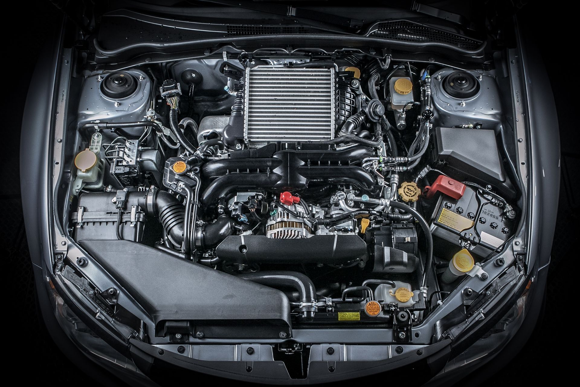 Open car engine bay with visible turbo intercooler and hoses, viewed from above