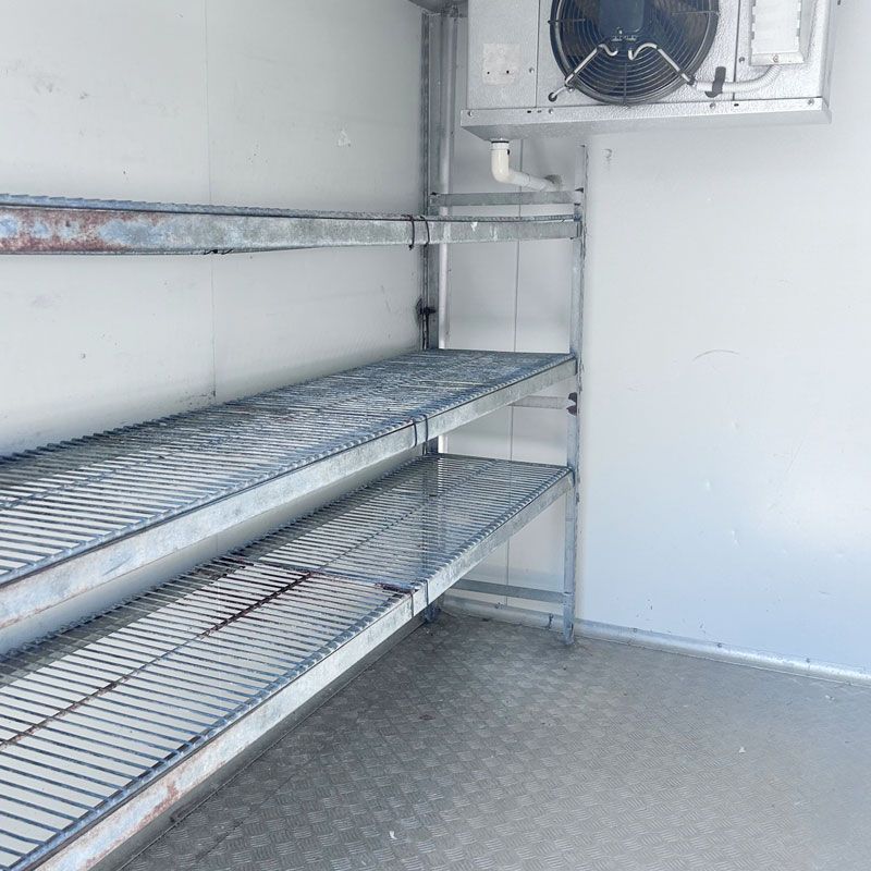 A room with shelves and a fan on the wall.