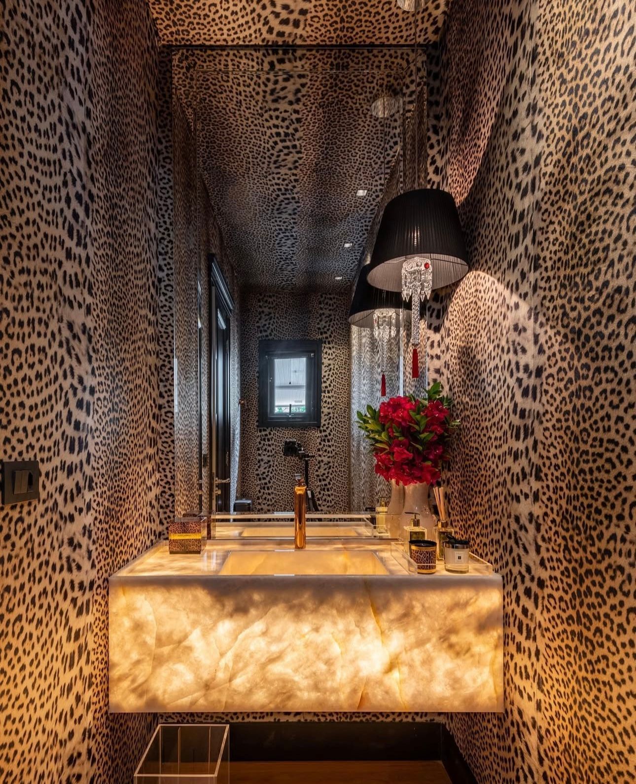 Um banheiro com uma parede com estampa de leopardo e uma pia