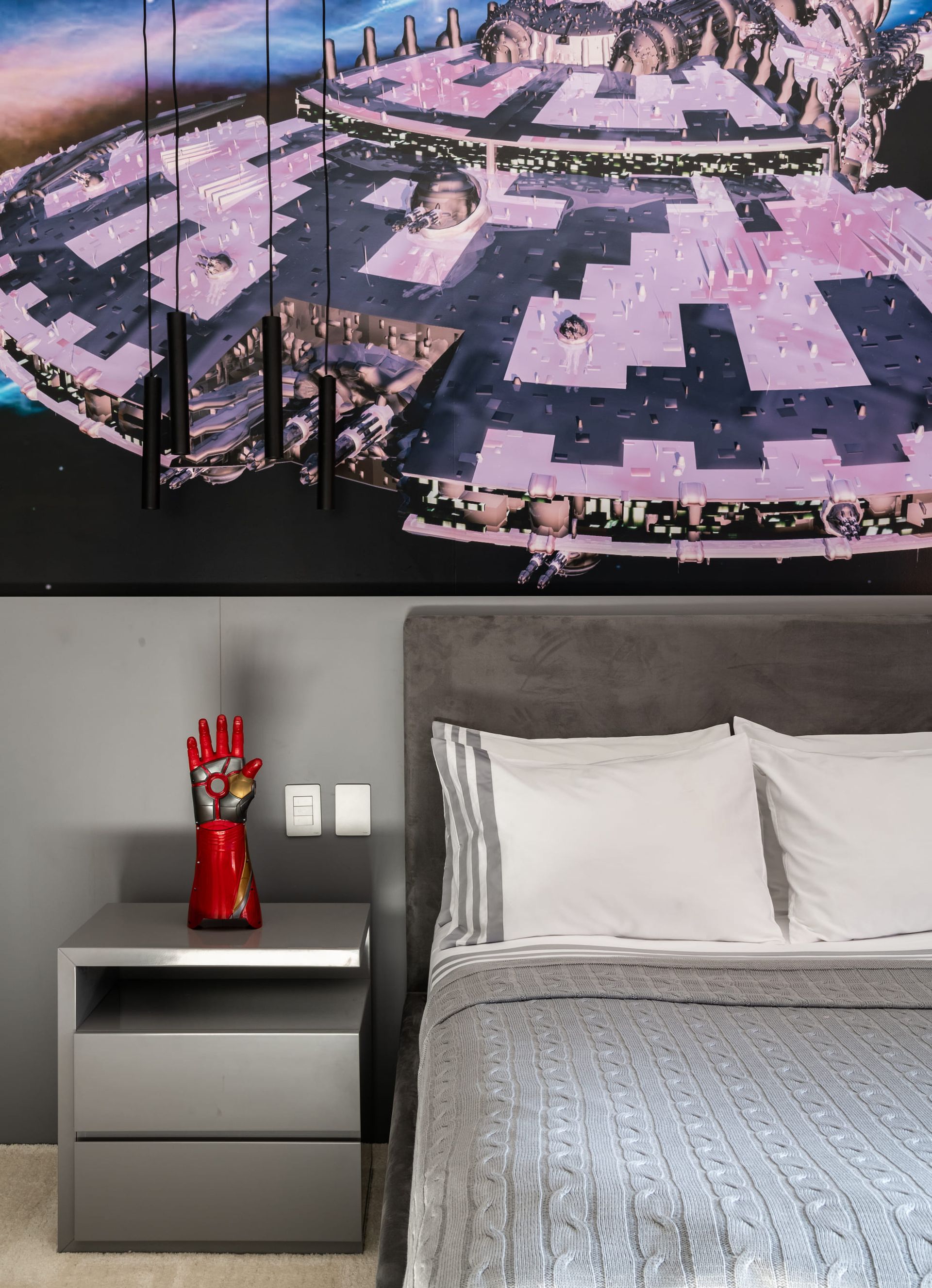 Um quarto com uma cama, mesa de cabeceira e uma pintura na parede acima da cama.